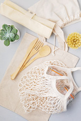 Zero waste concept. Set of eco friendly bamboo cutlery, mesh cotton bag, reusable coffee tumbler. Sustainable, ethical shopping, plastic free lifestyle. top view, flat lay.