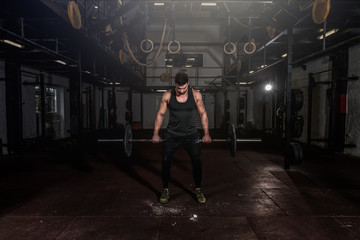Fototapeta na wymiar Young strong sweaty fit muscular veteran guy with scars on his skin preparing for heavy cross weightlifting or dead lifting workout training in the gym for rehabilitation