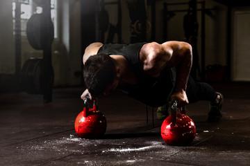 Young strong fit sweaty muscular veteran  man with scars on big muscles doing push ups on two big...