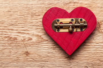 Red heart on old wooden background with latch