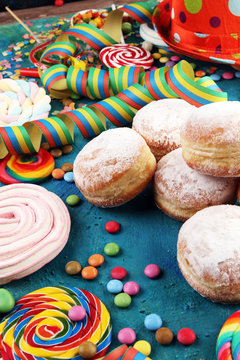 Carnival powdered sugar raised donuts with paper streamers. German berliner or krapfen for carnival