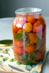 Pickled tomatoes in an open jar