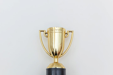Simply flat lay design winner or champion gold trophy cup isolated on white background. Victory first place of competition. Winning or success concept. Top view copy space.