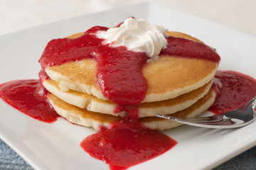 stack of pancakes with raspberry sauce