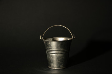 small stainless bucket on a dark background