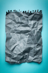 crumpled sheet of gray paper on a blue background. mocap grey paper