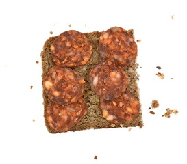 Slice of wholemeal dark bread with smoked sausage isolated on a white background in close-up (high details)