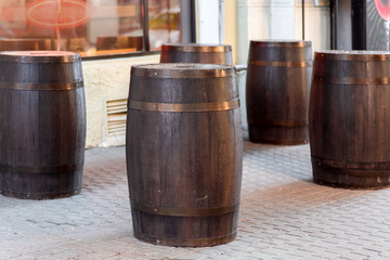 brown wooden wine barrel on the street on stone paving slabs, bar restaurant decorations close up nobody.