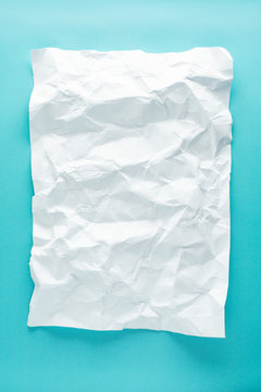 crumpled sheet of white paper on a blue background. mocap white paper
