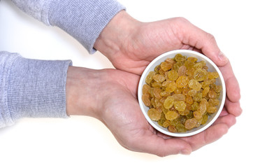 Male hands holding bowl with raisins