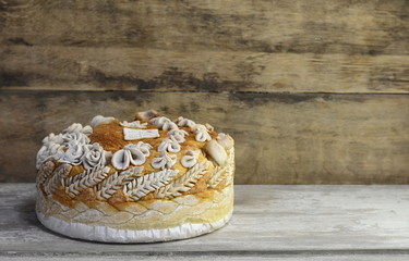 Homemade decorated Serbian slava bread on the rustic wooden board.