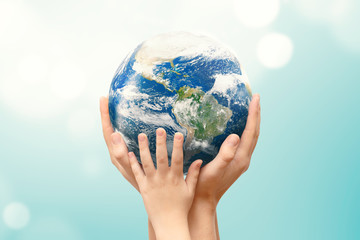 Earth globe in family hands. World environment day. Elements of this image furnished by NASA.