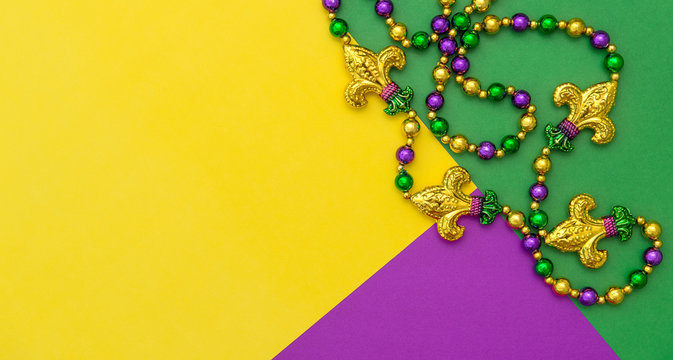 Mardi gras carnival decoration beads yellow green purple background