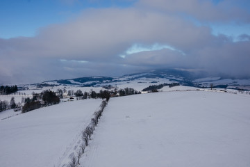 Fototapeta na wymiar Snowy road to the near village, Dolni Hedec, Czech Republic.