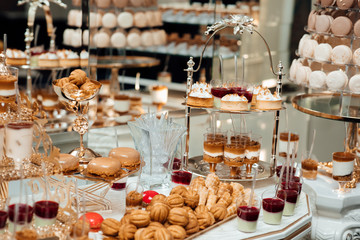 Banquet table full of fruits and berries and an assortment of sweets. Stylish luxury decorated candy bar for the celebration of a wedding of happy couple, catering in the restaurant.  Luxury life. 