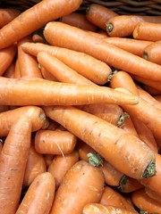 large ripe washed red carrots on a store counter awaiting buyers