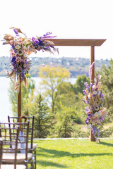 A beautiful venue for an open-air wedding ceremony. Wedding arch and rows of guest chairs on a green lawn overlooking the river