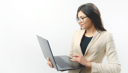 Portrait of attractive cheerful brunette using laptop holding it in her hands, isolated white background