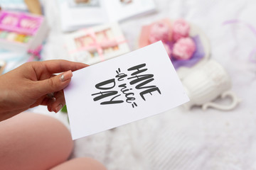 Girl holds a card with the inscription have a nice day