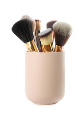 Set of professional makeup brushes in holder isolated on white