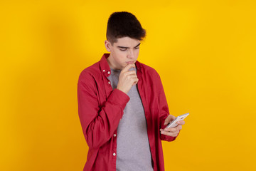 young teenage man with mobile phone isolated on background