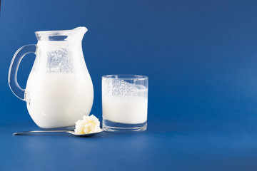 Homemade fermented beverage kefir with kefir graiuns on a trendy blue background, concept of natural fermented food and intestinal health