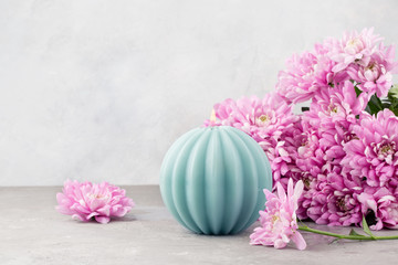 Valentine's day. Candle and pink flowers on a light grey background. Copy space.