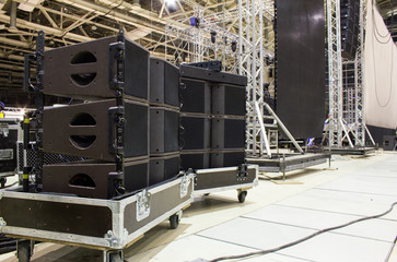 Flight cases with line array speakers. Stage, trusses, led screen and sound speakers background....