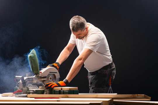 Carpenter working on woodworking machines in carpentry shop