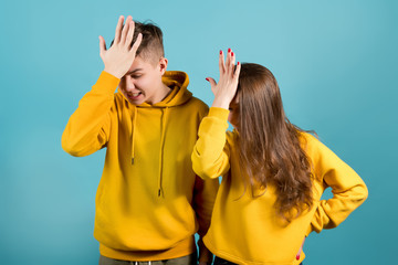 facepalm of brother and sister in yellow hoodies