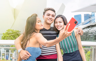 Three asian friends taking selfies outdoor. Friendship and holiday concept