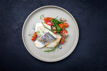 Gebratenes italienisches Kabeljau Fisch Filet mit Brokkoli, Queller und Tomaten als Draufsicht auf...