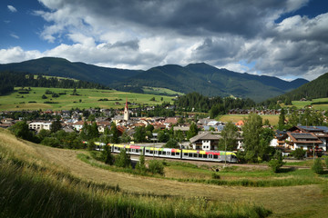 The Alpine Train passing through Monguelfo in Val Pusteria. South Tyrol in Italy.