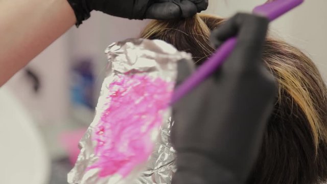 Professional hairdresser woman washes hair dye girl.