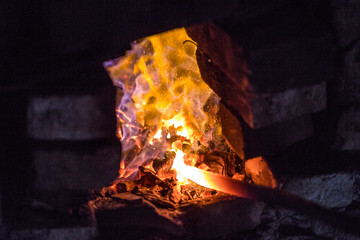 In a blacksmith's workshop. The metal billet is held in a coal flame in a furnace. An example of...