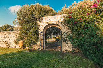 Fototapeta na wymiar Old arc gateway in a garden in Italy 