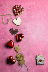 Red hearts made of ceramics, thin wire, beads and eucalyptus leaves in the form of a heart, a house with a window-heart, composed in a vertical composition, top view, copying space. For Valentines Day