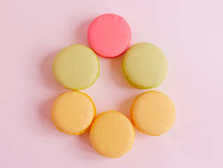 Fototapeta na wymiar pastel colored macaroons in the shape of an Easter egg, creative minimalist Easter pink background