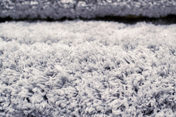 Texture of long-pile carpet. Abstract background of a shaggy grey carpet pile texture with long...