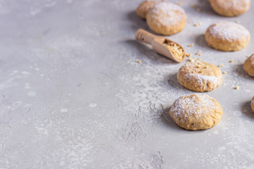 Fototapeta na wymiar Fresh baked butter cookies with peanut sprinkled with powdered sugar. Light grey stone background. Selective focus. 