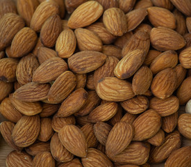 Almond Nut mixed salt is Protein food and healthy food for diet food in a wooden plate on a black background.