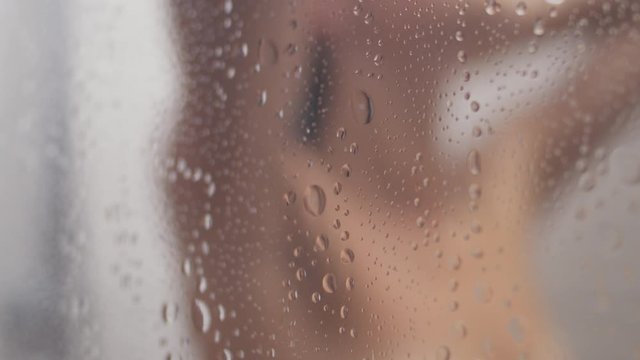 Blurred silhouette of a woman taking a shower