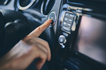 Naklejka premium Close up male hand touch control panel before purchasing a new automobile in showroom.