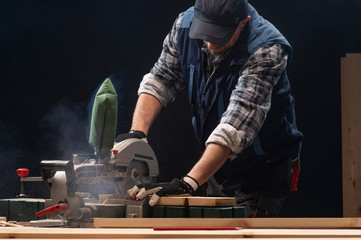 Carpenter working on woodworking machines in carpentry shop