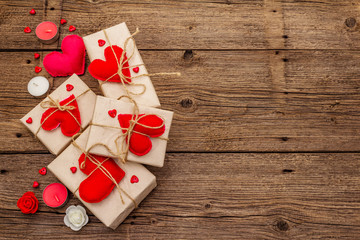 Zero waste gift concept. Valentine Day or Wedding eco friendly packaging. Festive boxes in craft paper with red felt hearts. Vintage wooden background