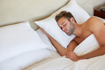 Young man sleeping comfortably in bed in the morning