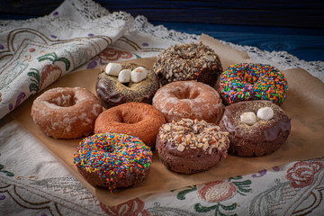 Beautiful doughnuts covered in chocolate glaze, sprinkles,  marshmallows and chopped nuts
