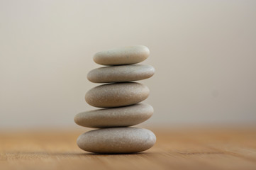 Fototapeta na wymiar Stone cairn on wooden background, five stones tower, simple poise stones, simplicity harmony and balance, rock zen