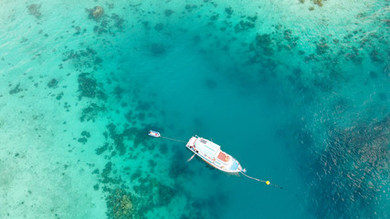 Boat anchored on the coral reef, aerial view from drone