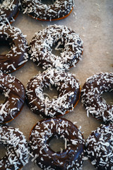 Fresh donuts with chocolate icing and coconut flakes